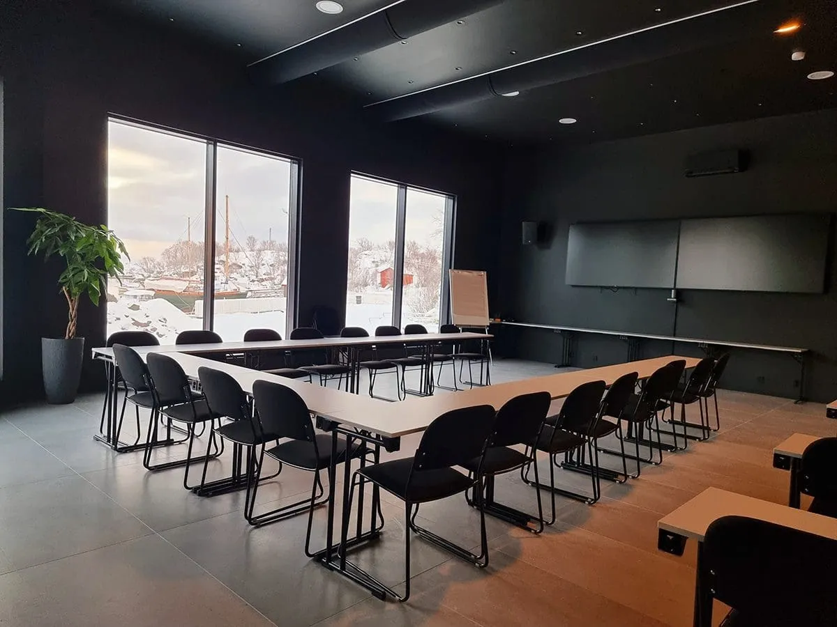 møterom med bord og stoler med utsikt mot båthavna