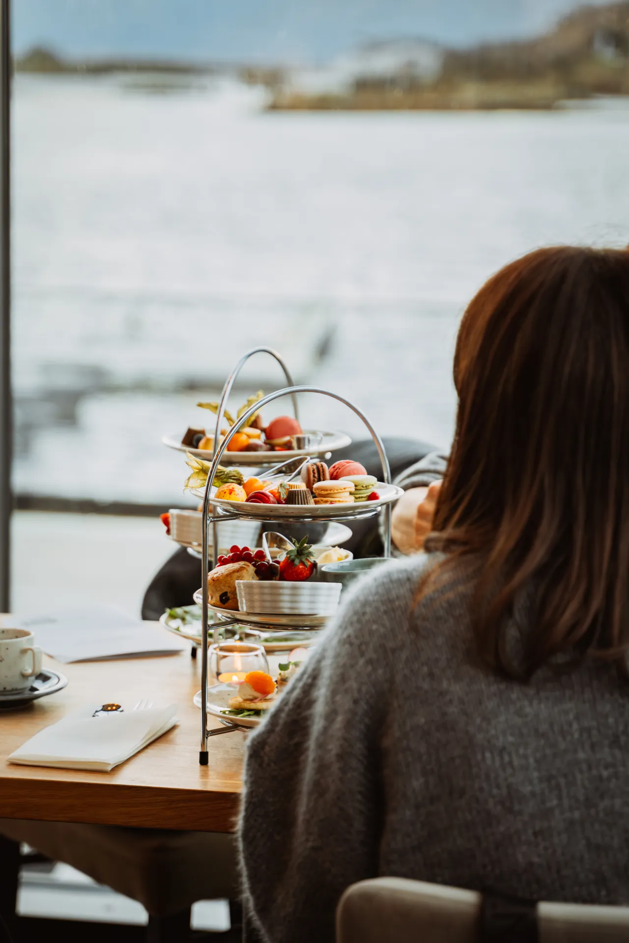 en person som sitter ved et bord med afternoon tea på